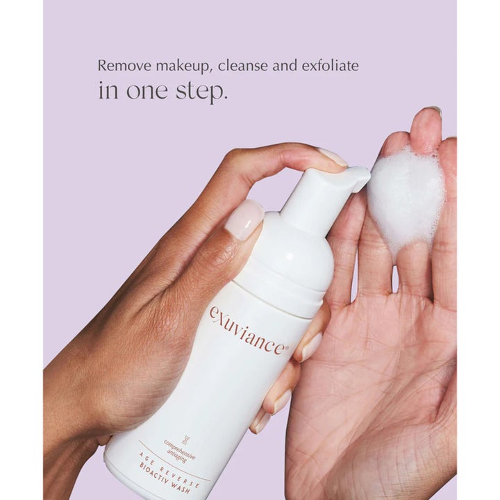 Exuviance Age Reverse BioActiv Wash 125 ml eksfolierende rens i hvit pumpeflaske med fyldig hvitt skum i en hånd