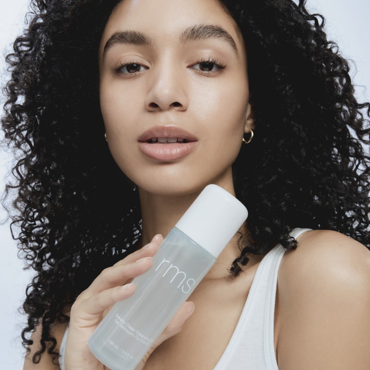 RMS Beauty Kakadu Clean Cleansing Gel 100 ml ansiktsrens holdes av kvinne med glødende hud