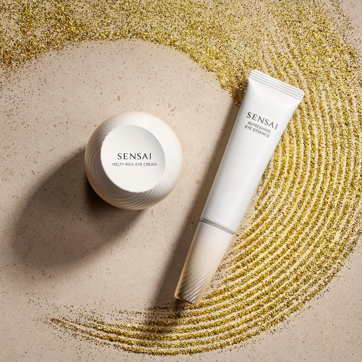 Sensai Refresh Eye Essence Refill 20 ml oppfriskende øyeessens hvit tube og krukke omgitt av glitrende gullstøv