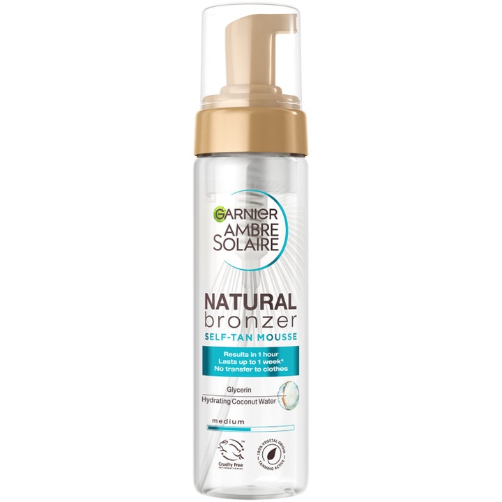 Garnier Ambre Solaire Natural Bronzer Self-Tan Mousse gir glød i en klar plastflaske med gullfarget pumpe og lokk