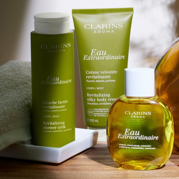 Clarins Eau Extraordinaire Revitalizing Shower Milk 200 ml revitaliserende dusjsåpe i grønn flaske i spa-miljø