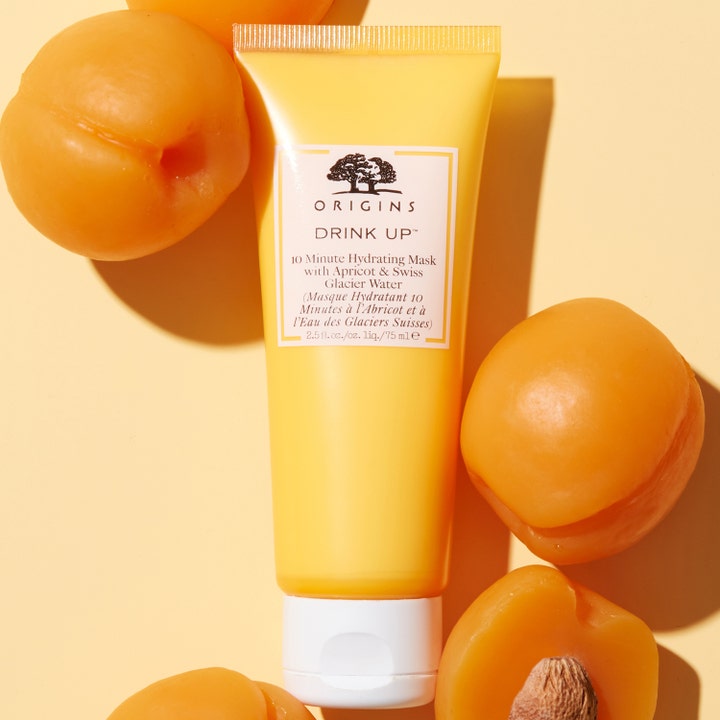 Origins Drink Up 10 Minute Mask 75 ml fuktighetsgivende ansiktsmaske i gul tube omgitt av friske aprikoser