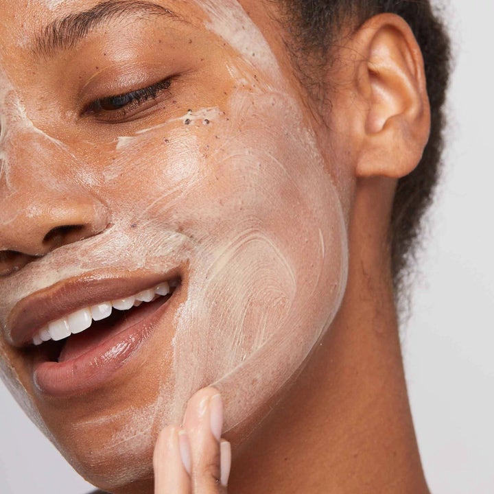 Dermalogica AGE smart Duo Multivitamin Power Recovery Masque ansiktsmaske påført på huden til en smilende kvinne.