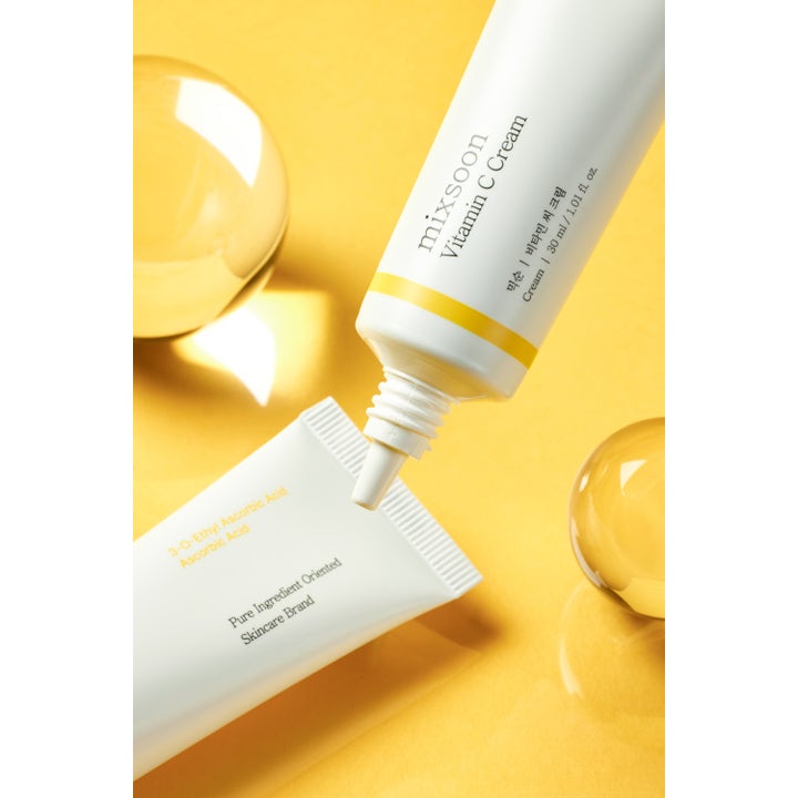 Mixsoon Vitamin C Cream 30 ml glødgivende ansiktskrem i hvite tuber på gul bakgrunn med klare glasskuler