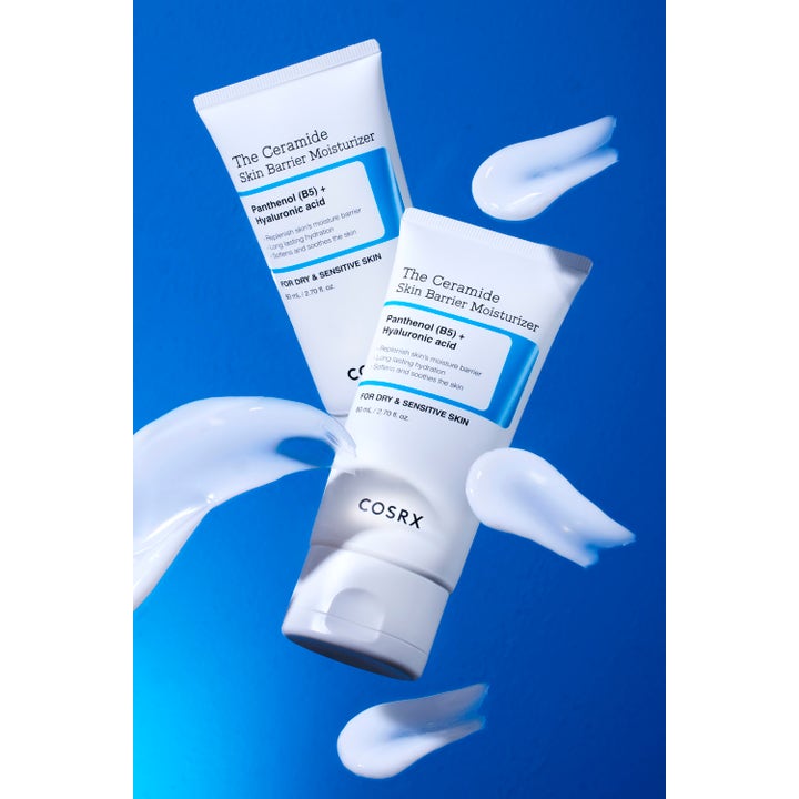 COSRX The Ceramide Skin Barrier Moisturizer 80 ml fuktighetskrem i hvite tuber med kremet tekstur på blå bakgrunn