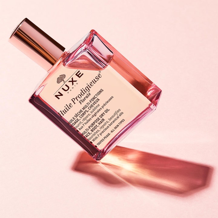 Nuxe Huile Prodigieuse Florale 50 ml pleiende tørrolje i en firkantet glassflaske med rosegull-kork og rosa toner