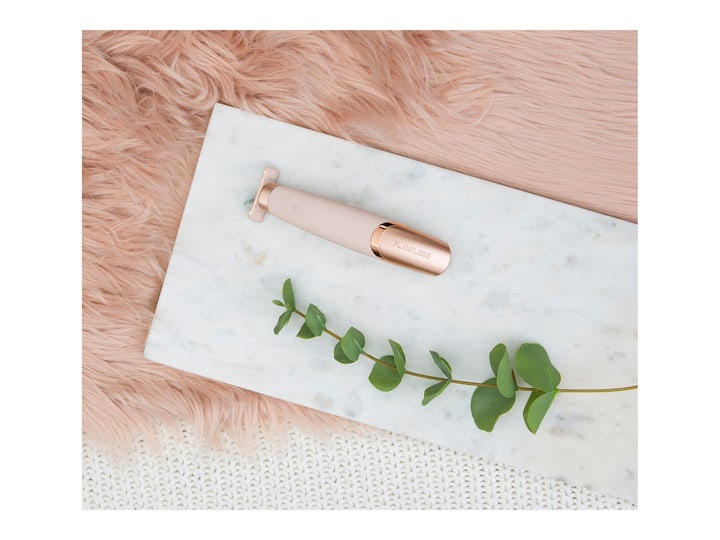 Flawless Nu Razor 1 stk til skånsom hårfjerning i rosegull på hvit marmorplate med grønn kvist og rosa fuskepels