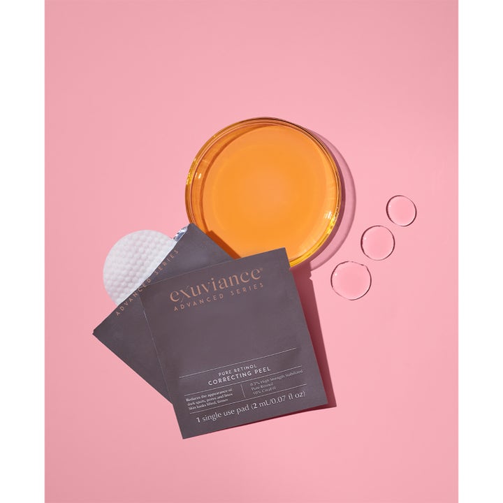 Exuviance Pure Retinol Correcting Peel 6 stk peeling som gir glød med grå sachet, hvit pad og oransje væske.