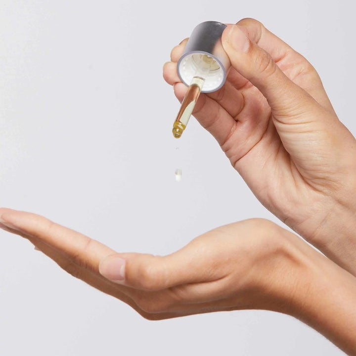 Dermalogica Retinol Clearing Oil Duo ansiktsolje med salisylsyre dryppes fra en pipette ned i en åpen hånd.
