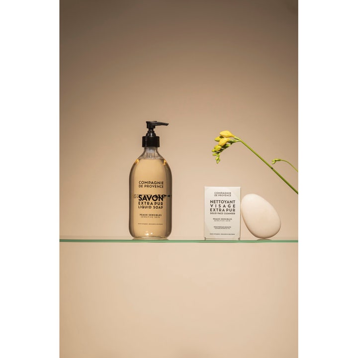 Compagnie de Provence Liquid Marseille Soap 495 ml beroligende håndsåpe i pumpeflaske ved siden av hvit ansiktsrens.