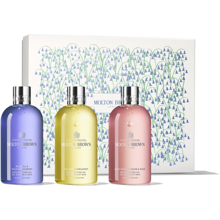 Molton Brown Bath & Shower Gel Trio 3x300ml oppfriskende dusjsåpe i lilla, gul og rosa flaske foran dekorert hvit gaveeske