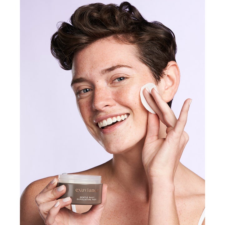 Exuviance Gentle Daily Exfoliating 60 Pads 55 ml ansiktspeeling som gir glød vist på person som bruker en pad.
