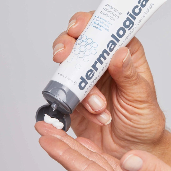 Dermalogica Intensive Moisture Balance 50 ml ansiktskrem i hvit tube som trykker ut fyldig hvit krem på fingrene