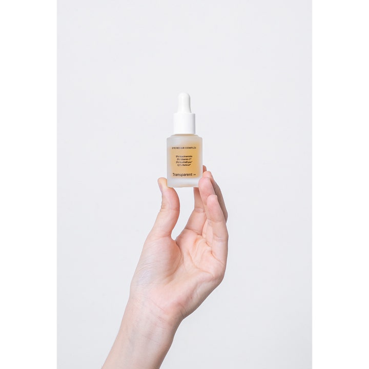 Niche Beauty Lab Transparent Lab Eye-Repair Complex 15 ml øyekrem med retinol i frostet glassflaske holdt i en hånd.