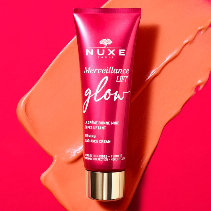 Nuxe Merveillance Lift Glow 50 ml oppstrammende dagkrem i rosa tube med gullkork på ferskenfarget kremtekstur.