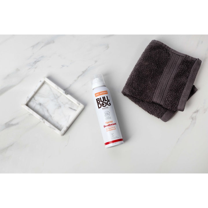 Bulldog Spray Deodorant Bergamot & Sandalwood 125 ml spray på marmorflate ved siden av en mørk grå klut