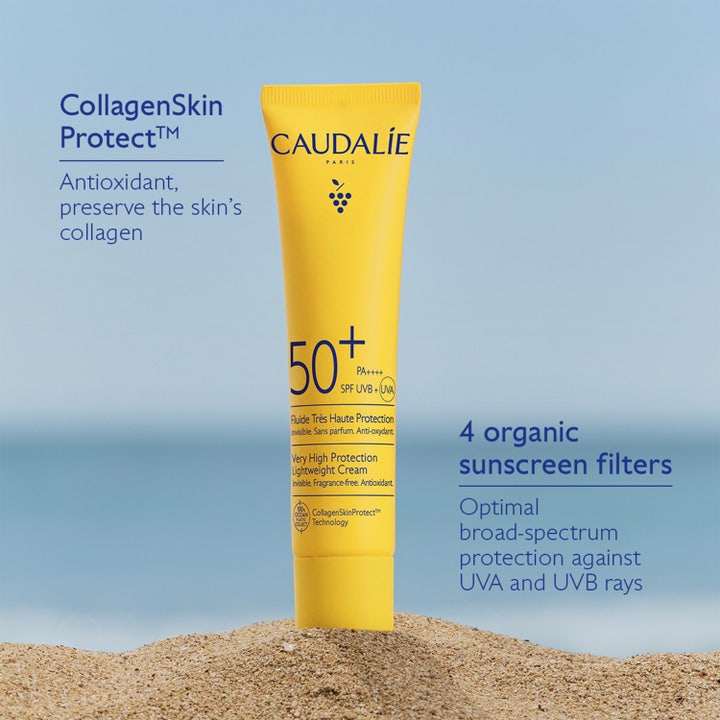 Caudalie Vinosun Lightweight Fluid SPF50 40 ml solkrem i gul tube på sanden som beskytter hudens kollagen