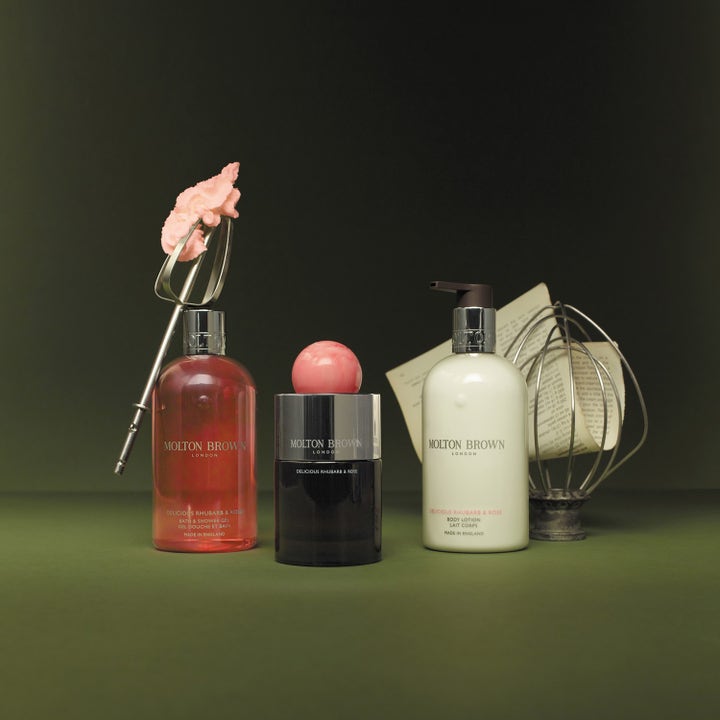 Molton Brown Delicious Rhubarb & Rose 300 ml dusjsåpe i et vakkert stilleben med body lotion og metallvisper