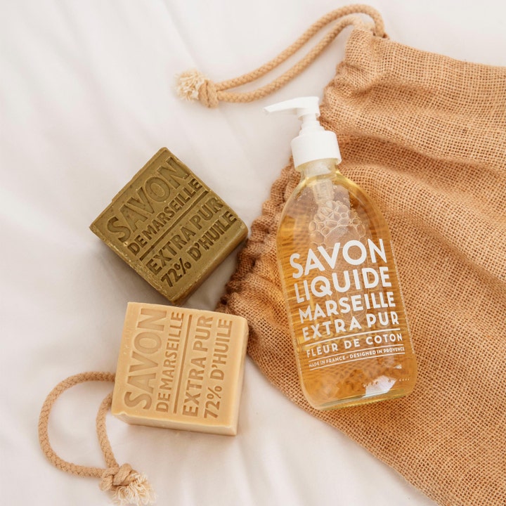 Compagnie de Provence Cube Of Marseille Soap Olive 400 g pleiende håndsåpe ved siden av flytende såpe og en jutepose