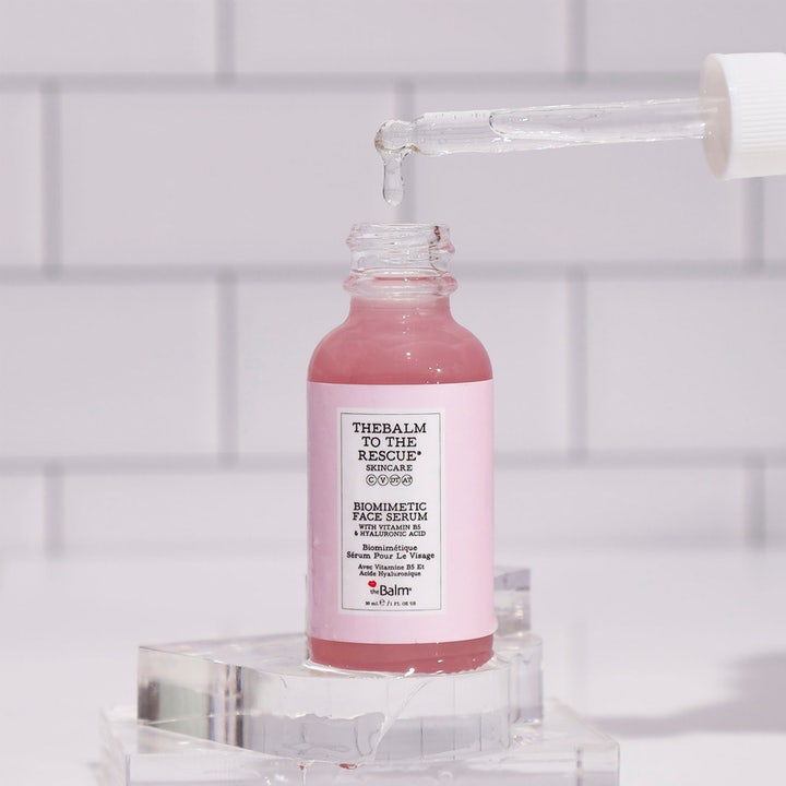 the Balm theBalm to the Rescue 30 ml fuktserum i rosa glassflaske med pipette som drypper klar væske