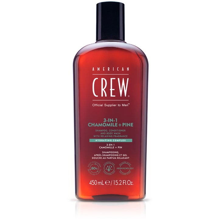American Crew 3-in-1 Chamomile + Pine 450 ml fuktighetsgivende dusjsåpe i en gjennomsiktig ravfarget flaske med sort kork