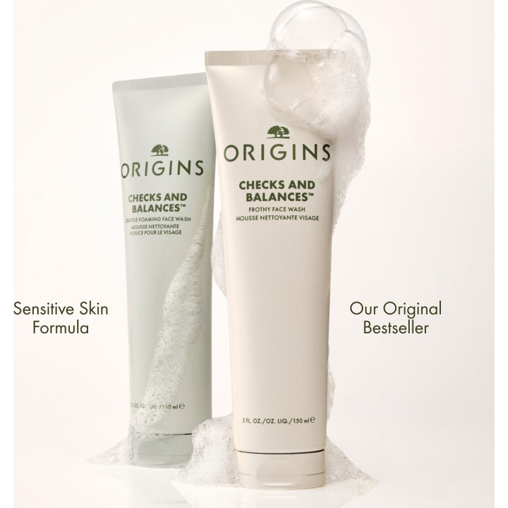 Origins Checks and Balances 150 ml ansiktsrens for sensitiv hud i to tuber omgitt av hvitt renseskum.