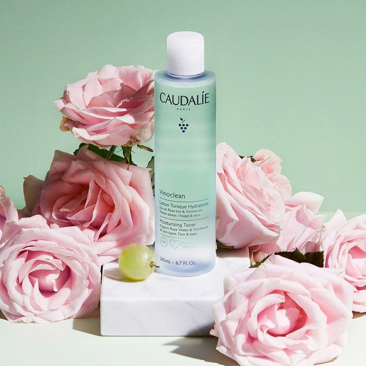 Caudalie Vinoclean Moisturizing Toner 200 ml fuktighetsgivende ansiktsvann i lyseblå flaske omgitt av rosa roser