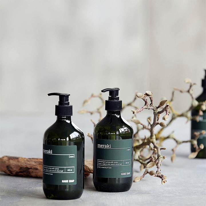 Meraki Hand Soap For Men 490 ml pleiende håndsåpe i mørkegrønne flasker med pumpe i en rustikk setting.