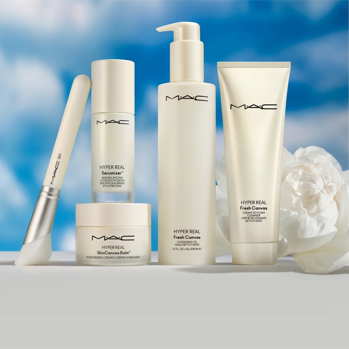 MAC Cosmetics Hyper Real Fresh Canvas Cream-To-Foam Cleanser 125 ml rengjøringsskum i hvit tube ved en hvit blomst.