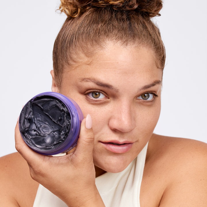 Clinique Take The Day Off Charcoal Detoxifying Cleansing Balm 125 ml avgiftende kullrens i lilla krukke vist av modell