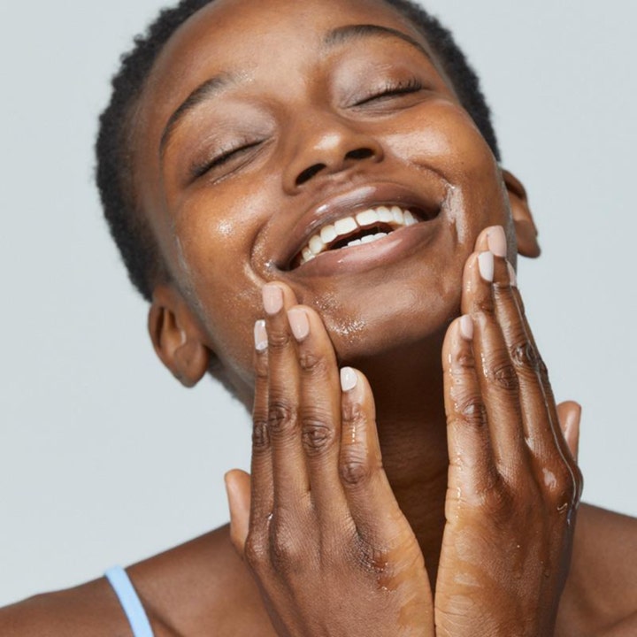 Dermalogica PreCleanse 30 ml ansiktsrengjøring i bruk av en kvinne som masserer den glødende oljen inn i ansiktet.