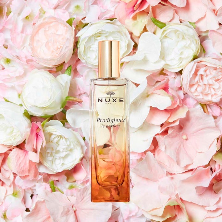 Nuxe Prodigieux Le Parfum 50 ml EdP med varm duft i glassflaske med gullkork omgitt av rosa blomster