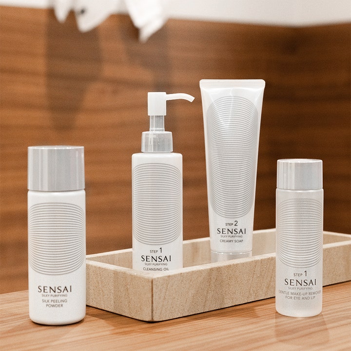 Sensai Silky Purifying Cleansing Oil Step 1 150 ml ansiktsrengjøring hvit pumpeflaske i et sett på et lyst brett