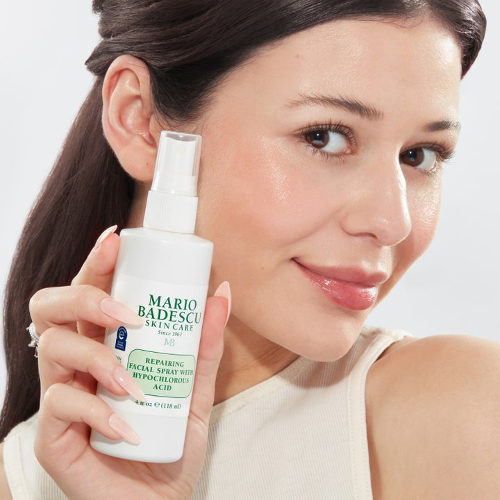 Mario Badescu Repairing Facial Spray 118 ml ansiktsspray holdes av en kvinne med glødende hud