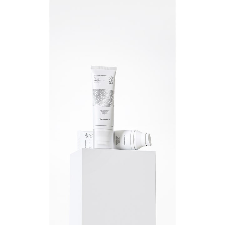 Niche Beauty Lab Transparent Lab Lightweight Sunscreen 100 ml beskytter huden med SPF 50+ i hvite tuber på hvit sokkel.