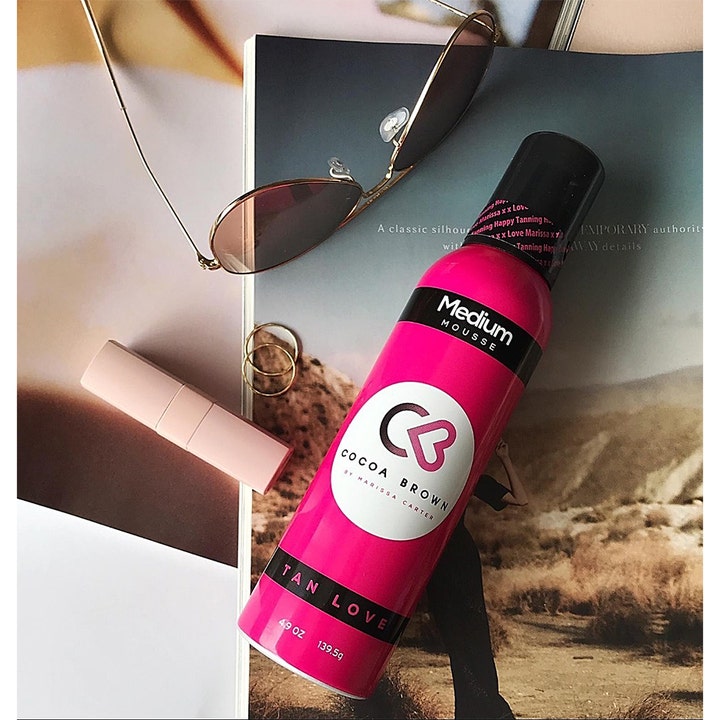 Cocoa Brown 1 Hour Tan Medium 150 ml selvbruningsmousse gir glød i rosa boks ved siden av solbriller på et magasin