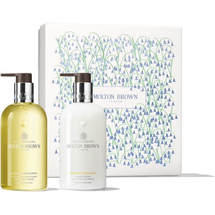 Molton Brown Orange & Bergamot Hand Care Set 2x300ml pleiende håndsett med gul såpe og hvit krem foran en mønstret gaveeske