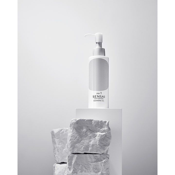 Sensai Silky Purifying Cleansing Oil 150 ml ansiktsrens på hvit sokkel med grove steiner.