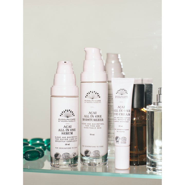Rudolph Care Açai All in One Serum 30 ml ansiktsserum i hvit pumpeflaske på en glasshylle sammen med andre produkter.