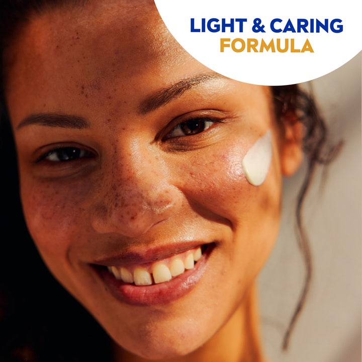 NIVEA UV Face Sensitive SPF50 50 ml solkrem for ansiktet påføres smilende kvinne med fregner