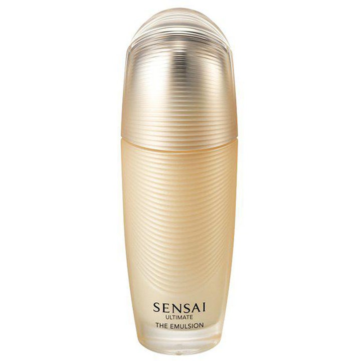 Sensai Ultimate The Emulsion 100ml nærende ansiktsemulsjon i en luksuriøs champagnefarget flaske med rillet tekstur.