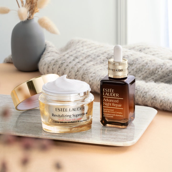 Estée Lauder Revitalizing Supreme+ Soft Cream 30 ml oppstrammende ansiktskrem i åpen gullkrukke ved siden av nattserum.