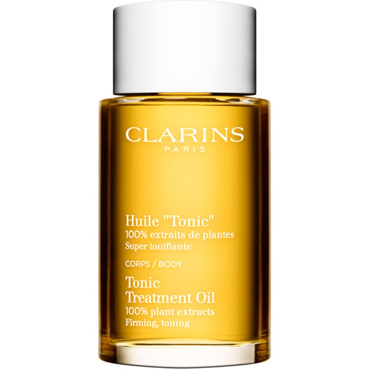 Clarins Tonic Treatment Oil oppstrammende kroppsolje i en gjennomsiktig glassflaske med gyllen olje og hvitt lokk.