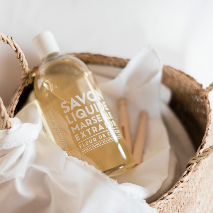 Compagnie de Provence Liquid Marseille Soap Refill Cotton Flower 1000 ml pleiende håndsåpe i klar flaske i flettet kurv.