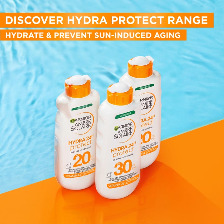 Garnier Ambre Solaire Hydra 24H Protect 175 ml solkrem med SPF 30 og Vitamin Cg i hvite flasker ved et basseng