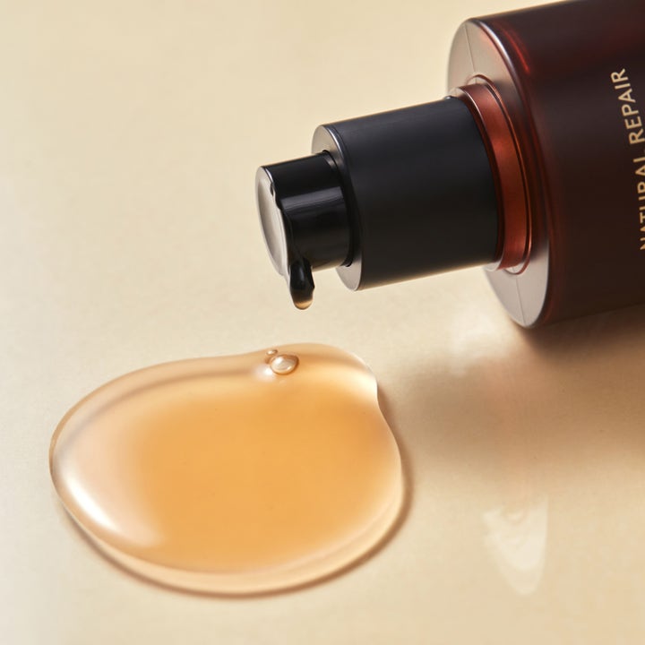 Hyggee Natural Repair Serum 120 ml reparerende ansiktsserum viser ravfarget flytende tekstur fra sort pumpe