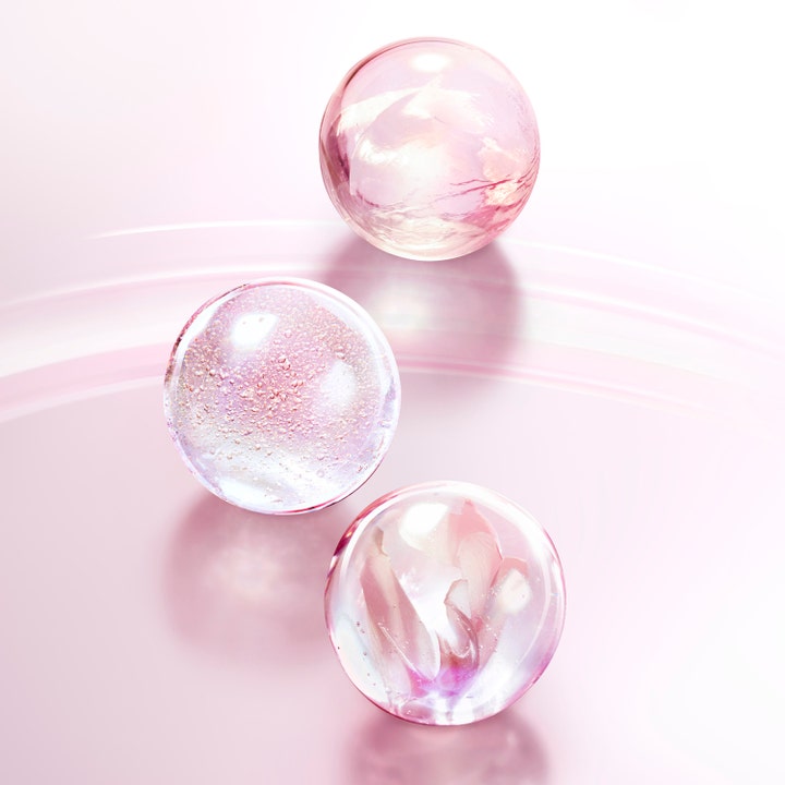 Lancôme Tonique Confort 400 ml beroligende toner vist som rosa kuler med bobler og roseblader på rosa bakgrunn.