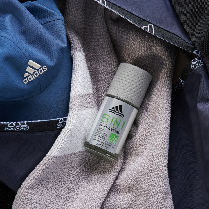 Adidas Cool & Dry 6 In 1 Roll-on Deodorant 50 ml mot svette og lukt liggende på et grått håndkle i en blå bag