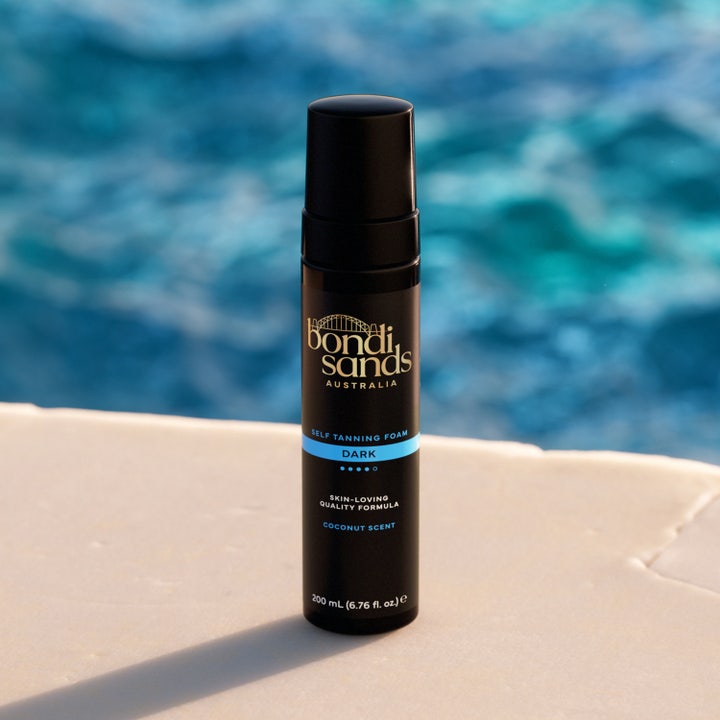 Bondi Sands Self Tanning Foam Dark 200 ml brun uten sol i svart pumpeflaske ved et blått basseng