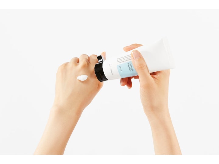 COSRX Ultimate Nourishing Rice Overnight Spa Mask 60 ml fuktighetsgivende nattmaske hvit kremtekstur på en håndrygg